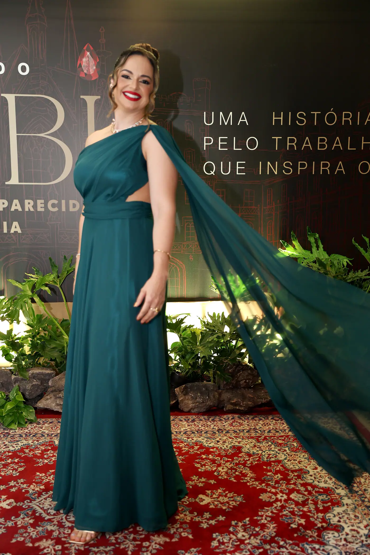 Traje de gala em frente ao painel do Baile do Rubi